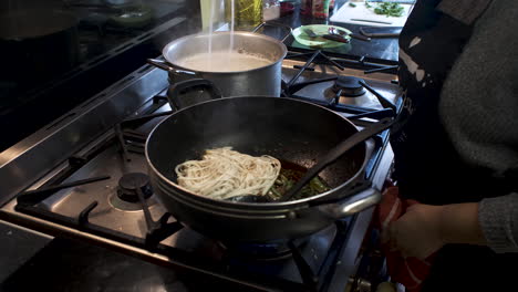 Chef-Placing-Cooked-Spaghetti-Noodles-In-Saucepan-For-Further-Mixing