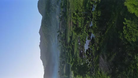 Vertical-drone-flight-over-tropical-landscape-with-mystic-flying-fog-during-blue-sky-in-summer---Puerto-Plata-Province,Dominican-Republic
