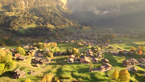 aerial-drone-footage-pushing-in-and-panning-down-over-Grindelwald-village-in-Switzerland,-Autumn