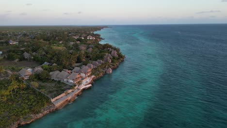 Beach-resorts-and-homes-in-Kusini-East-Zanzibar-Island-Tanzania-Africa,-Aerial-flyover-high-shot
