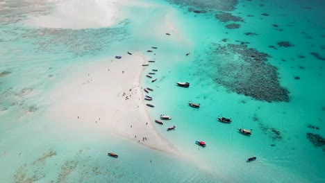 Snorkeling-tour-boats-in-sand-bank-at-Mnemba-island-atoll-near-Zanzibar,Tanzania-Africa-,-Aerial-pan-right-shot