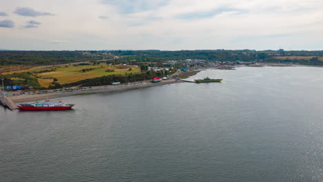 Aerial-Timelapse-showing-ships-in-the-Chacao-Channel,-bright-blue-sky-day-looking-over-Chiloe-Island