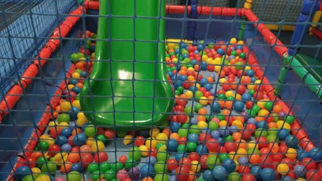 slide-in-the-ball-pool-with-net-and-foam-protection-to-blows-in-the-leisure-center-and-indoor-playground-very-colorful,-shooting-dolly-traveling-backwards,-Orders,-Galicia,-Spain