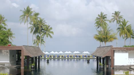Blick-Auf-Die-Luxuriösen-Strandliegen-Mit-Sonnenschirm-In-Der-Nähe-Des-Pools-Im-Resort-In-Thailand-Mit-Sonnigem-Sommerwetter-Und-Blauem-Himmel