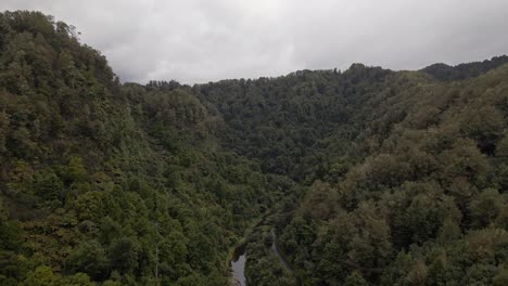 Aerial-establishing-shot-of-a-river-meandering-through-a-mountainous-jungle