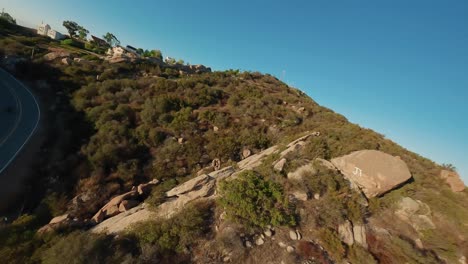 Fpv-drone-follow-Motorcycle-riding-along-Topanga-winding-road,-Stunt-tricks,-California