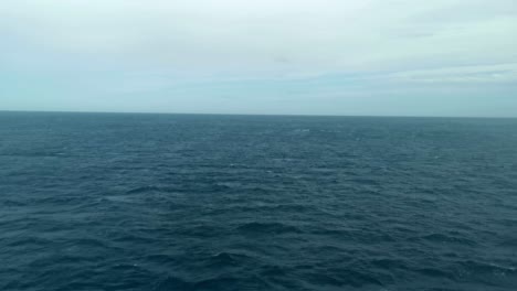View-outside-a-ferry's-window-with-no-land-visible,-only-vast-blue-ocean