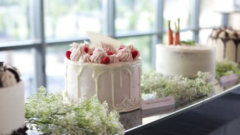 Panning-shot-showing-four-different-cakes-at-luxurious-indoor-wedding