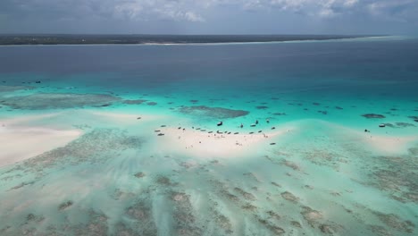 Mnemba-Island-Und-Atoll-Schnorchelparadies-In-Sansibar,-Tansania-Afrika-Mit-Tourbooten-Und-Besuchern,-Luftschwenk-Rechtsaufnahme
