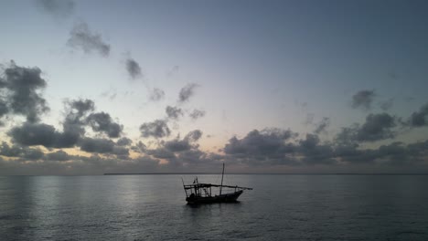 Boat-floating-near-Uroa-beach-in-Zanzibar-Island,-Tanzania-Africa-during-sunset,-Locked-shot