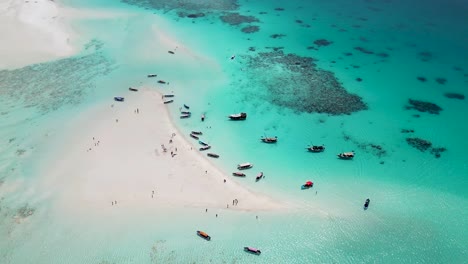 Snorkeling-tour-boats-in-Mnemba-island-atoll-near-Zanzibar,Tanzania-Africa-coral-reef,-Aerial-pan-right-shot