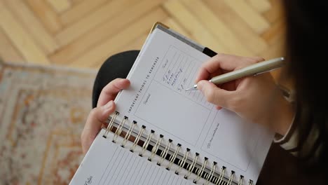 Frau-Schreibt-Einen-Zeitplan-In-Ihr-Agenda-Papierbuch