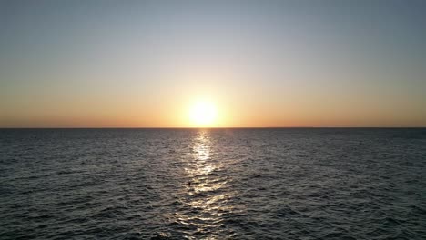Indischer-Ozean-Sonnenuntergang-Am-Kusini-Beach-Ostinsel-Sansibar-Mit-Strohschirm,-Tansania-Afrika,-Luftüberführungsaufnahme