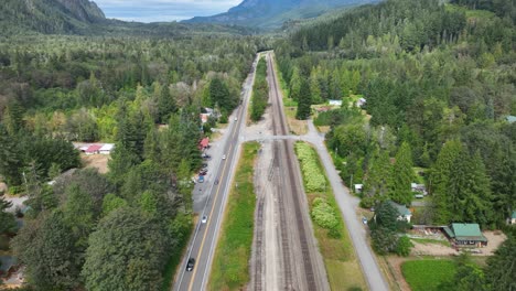 Aerial-view-of-vacant-train-tracks-running-parallel-to-highway-US-2-in-the-Cascade-Mountains