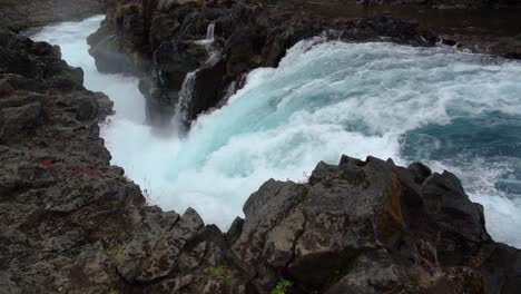 Spectacular-blue-colored-waterfall-crashing-down-edge-in-slow-motion-in-Iceland