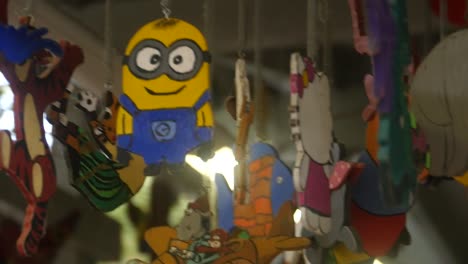 Camera-pans-around-a-wooden-figure-of-a-Minion,-hanging-from-the-ceiling