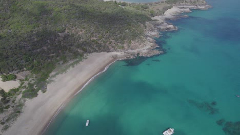 Wreck-Beach-With-Boats-On-The-Turquoise-Ocean-In-Great-Keppel-Island,-QLD,-Australia---aerial-drone-shot