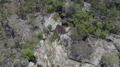Vista-De-Arriba-Hacia-Abajo-De-Las-Cascadas-De-Agua-En-Las-Cataratas-De-Emerald-Creek-En-Mareeba,-Australia-Durante-El-Día---Toma-Aérea-De-Drones