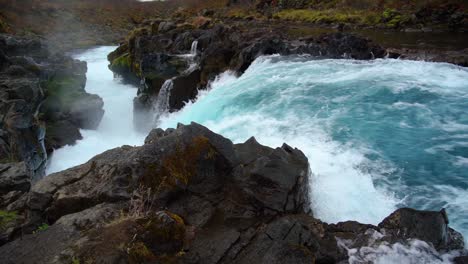 Slow-motion-shot-of-natural-waterfall-splashing-between-rocks-in-Iceland