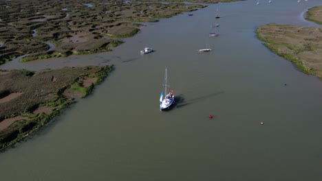 Sailboat-on-Blackwater-River-by-Swampy-Marshes-of-Tollesbury-Marina,-Essex,-UK---Aerial