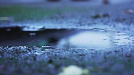 Two-big-water-drops-falling-in-a-puddle-on-the-concrete