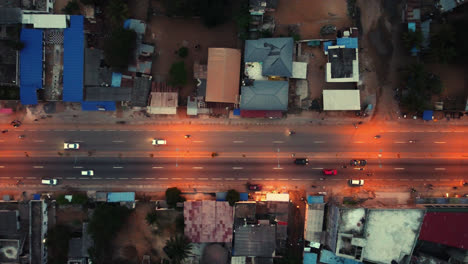 Filmische-4k-Reise-Von-Oben-Nach-Unten-Luftdrohnenaufnahme-Des-Straßenverkehrs-Bei-Nacht-Mit-Autos,-Die-Während-Der-Hauptverkehrszeit-In-Der-Afrikanischen-Stadt-Fahren---Lomé,-Afrika