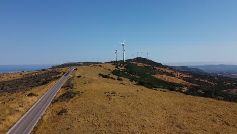 Generating-green-energy-on-top-of-Spanish-mountains,-aerial-fly-backward-view