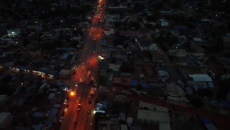 Toma-Aérea-Cinematográfica-De-4k-Del-Tráfico-Por-Carretera-En-La-Noche-Con-Automóviles-Conduciendo-Durante-La-Hora-Pico-En-Una-Ciudad-Africana-Cerca-Del-Océano---Lomé,-Togo