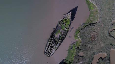 Drohne-Aufsteigend-über-Zerstörtem-Schiff-In-Salzwiesen-In-Tollesbury-Marina,-Essex,-Vereinigtes-Königreich