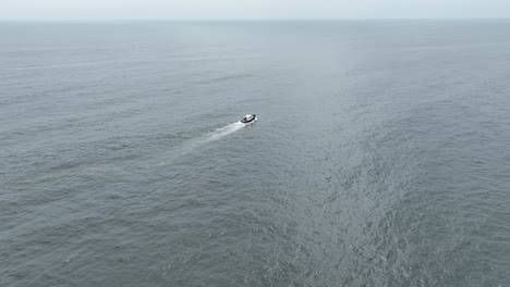 Luftschwenk-Eines-Bootes,-Das-An-Einem-Sonnigen-Tag-Mit-Ruhigen-Wellen-über-Das-Meer-Im-Pazifischen-Ozean-Segelt