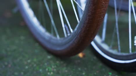 Slow-motion-camera-pan-over-backwheel-spokes-of-an-oldschool-locked-bicycle