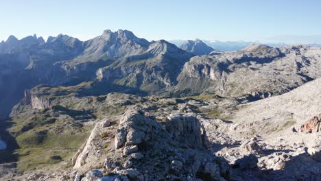 Persona-Sentada-En-El-Pico-De-Una-Montaña-En-Dolomitas-Italianas,-Muñeca-Aérea-Fuera