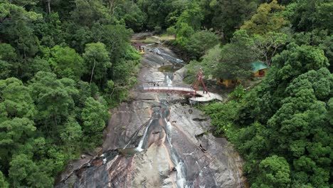 Turistas-En-La-Impresionante-Cascada-Telaga-Tujuh-Con-Plataforma-De-Observación-Sobre-Piscinas-Rocosas-En-Langkawi,-Malasia