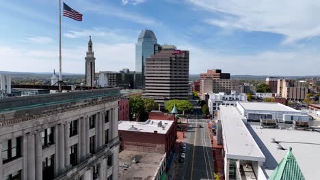 aerial-push-past-american-flag-atop-building-in-springfield-massachusetts