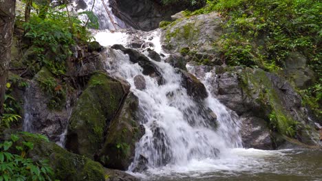 Mittlerer-Schuss-Des-Wasserfalls,-Der-Aus-Dem-Grünen-Dschungel-In-Einen-Kleinen-Teich-Fällt