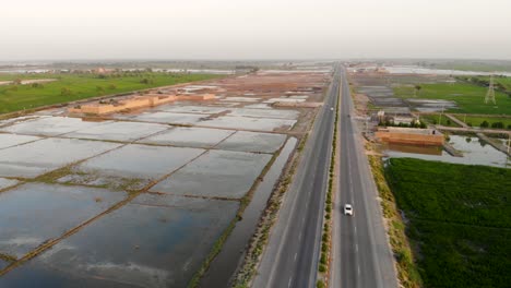 Aerial-View-Of-Highway-Cutting-Through-Rural-Jacobabad-With-Water-Logged-Fields-On-Left-Hand-Side