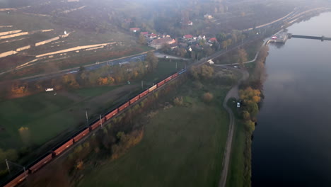 Driving-train-along-Elbe-river-near-Melnik-city-in-Czech-Republic,-drone-view