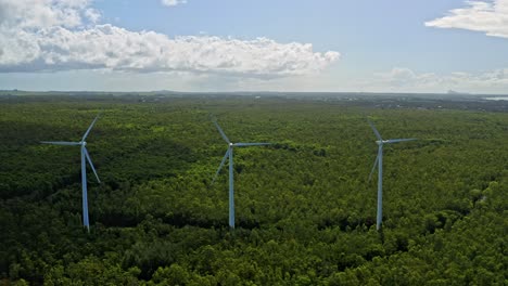 Drone-pullback-view-of-spinning-wind-turbines-in-La-Plaine-des-Roches,-Mauritius