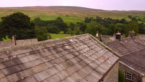Drone-aerial-reveal-across-across-Yorkshire-Dales-village-and-landscape