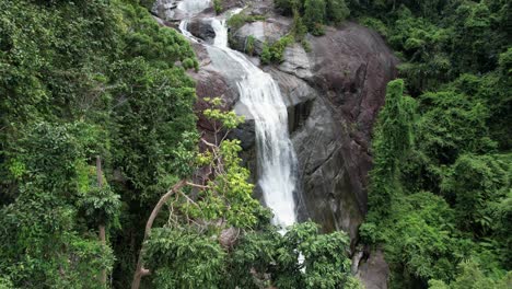 Flying-Through-Tree-Foliage-Of-Tropical-Forest-With-Telaga-Tujuh-Waterfall-In-Langkawi,-Kedah,-Malaysia