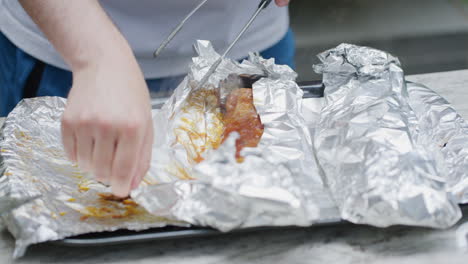 View-Of-Foil-Wrapped-BBQ-Ribs-Being-Placed-Next-To-Each-Other-And-Being-Unwrapped-With-Steam-Seen-Rising