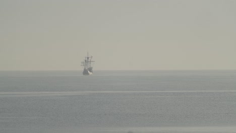 Ferdinand-Magellan-Nao-Victoria-Carrack-Bootsreplik-Mit-Spanischer-Flagge-Segelt-In-Der-Ferne-Im-Mittelmeer-Bei-Sonnenaufgang-In-Ruhiger-See-In-Zeitlupe-60fps