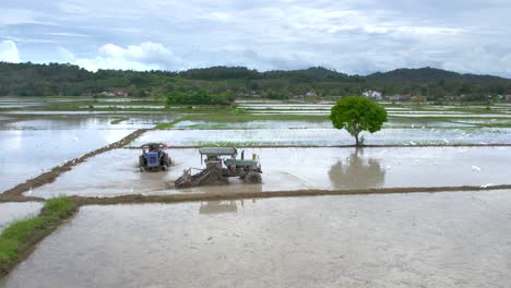 Plowing-Tractors-Preparing-Soil-For-Sowing-In-The-Paddy-Fields-At-Kampung-Mawar,-Langkawi-Malaysia