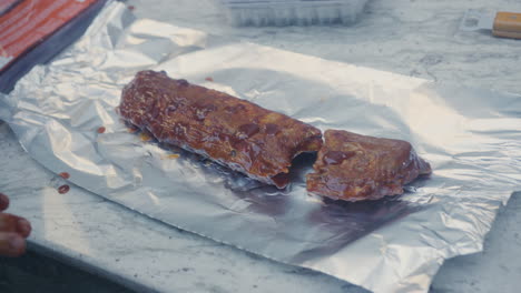 Hands-Adding-Marinating-Sauce-To-BBQ-Ribs-Before-Wrapping-In-Foil-Ready-To-Be-Cooked
