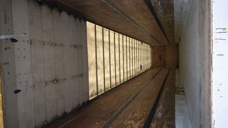 Looking-into-an-empty-white-semi-truck-cargo-trailer-before-receiving-packages,-vertical