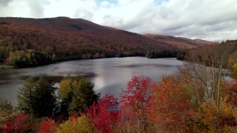 Antenne-über-Baumkronen-Mit-Blattfarbe-Im-Herbst-In-Vermont-Mit-See-Im-Hintergrund