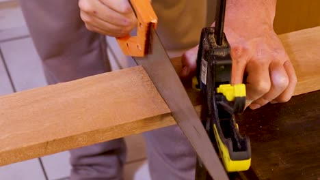 Handsaw-Tool-being-used-by-Tradesman,-Wood-Clamp-In-Shot