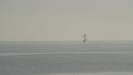 Ferdinand-Magellan-Nao-Victoria-carrack-boat-replica-sails-in-the-distance-in-the-mediterranean-at-sunrise-in-calm-sea-in-slow-motion-and-out-of-focus-60fps