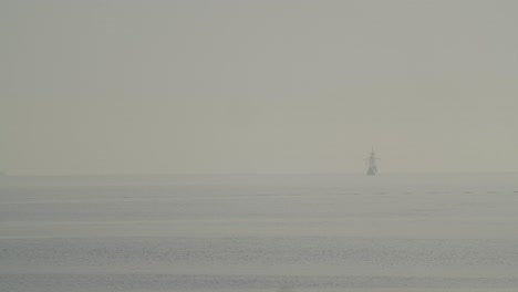 Ferdinand-Magellan-Nao-Victoria-carrack-boat-replica-sails-in-the-distance-in-the-mediterranean-at-sunrise-in-calm-sea-in-slow-motion-60fps