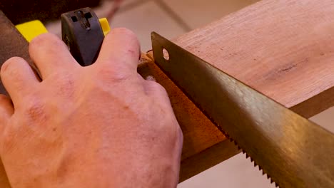 Close-Up-Shot-of-Tradesmen-hand-sawing-a-piece-of-Wood
